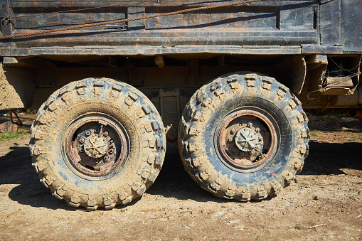 A wheel from a big truck in the coming. Off-road traffic.