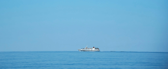 The movement of a white yacht on the surface of the sea or ocean. Side view