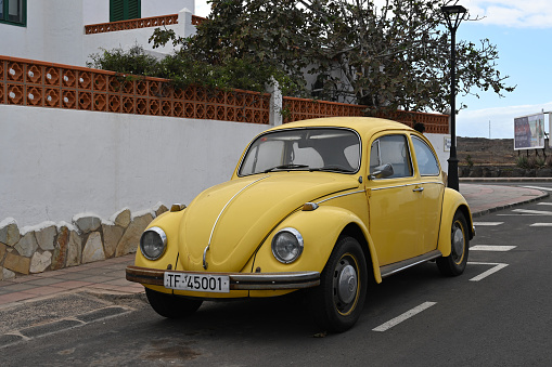 Corralejo, Fuerteventura, Spain, November 24, 2023 - An old yellow Volkswagen Beetle (VW 1300) from 1968