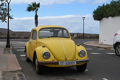 Corralejo, Fuerteventura, Spain, November 24, 2023 - An old yellow Volkswagen Beetle (VW 1300) from 1968