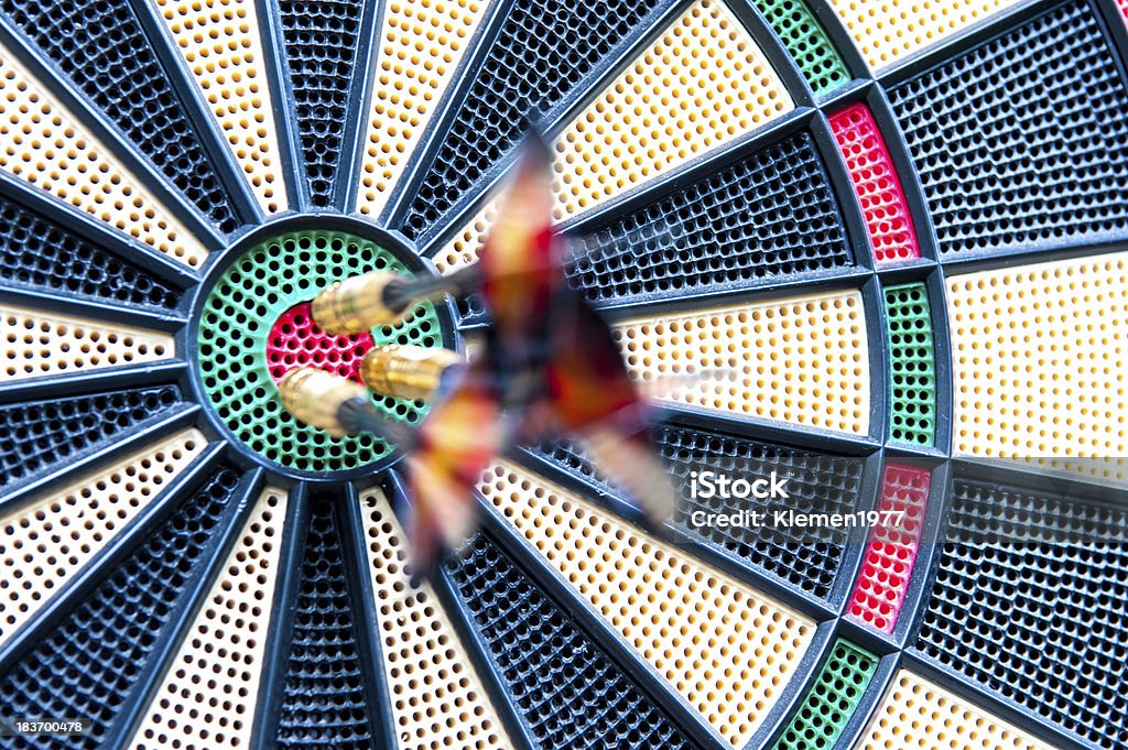 Blurred darts stuck in bulls-eye Three blurred darts with focus on them being stick in bulls-eye position on dart board. Sports Target Stock Photo