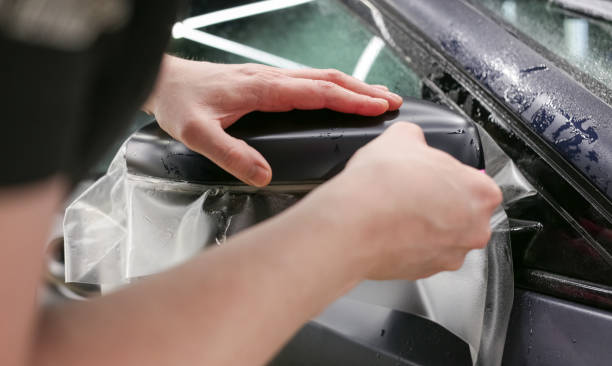 istock The process of installing PPF on the side mirror. The process of installing PPF on the car. PPF is a polyurethane, protective film that protects the paint from scratches and gravel. Car wrapping. 1837027709