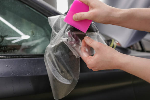 istock The process of installing PPF on the side mirror. The process of installing PPF on the car. PPF is a polyurethane, protective film that protects the paint from scratches and gravel. Car wrapping. 1837027715
