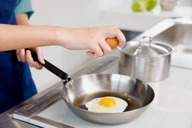 istock Woman frying an egg in the kitchen 1837032905