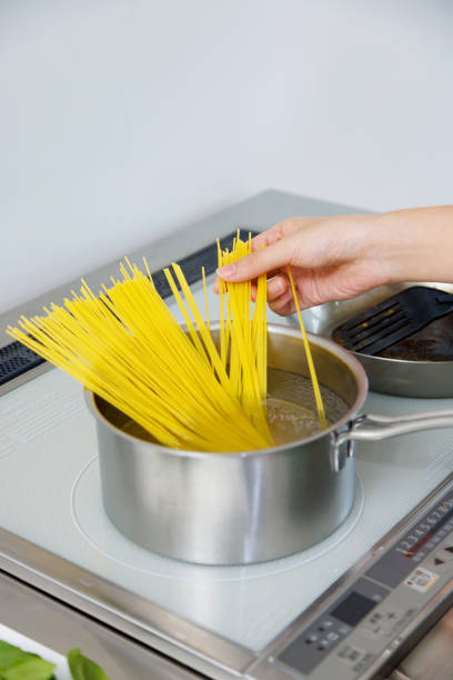 istock Woman cooking spaghetti in the kitchen 1837034485