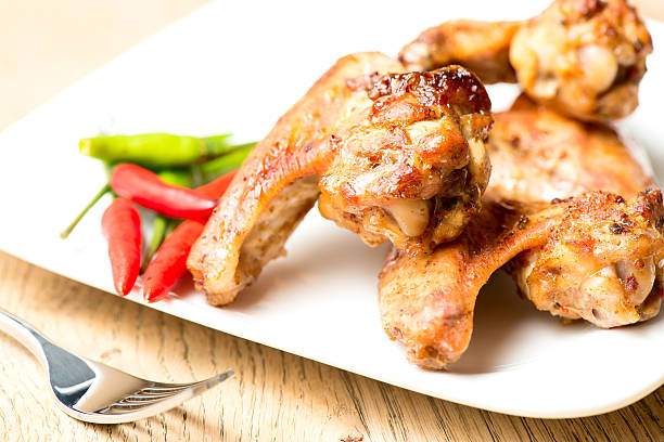 Hot chicken wings on plate with chilli peppers