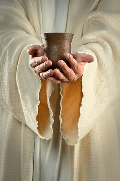 istock Jesus in white robes holding a pottery cup 183707125