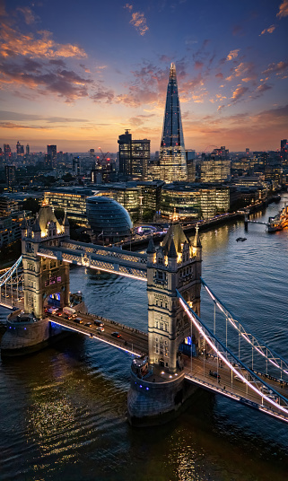 Beautiful aerial view of the illuminated Tower Bridge and skyline of London, UK, just after sunset