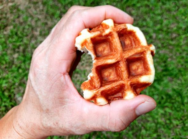 istock Hand holding Waffle - green background. 1837086955