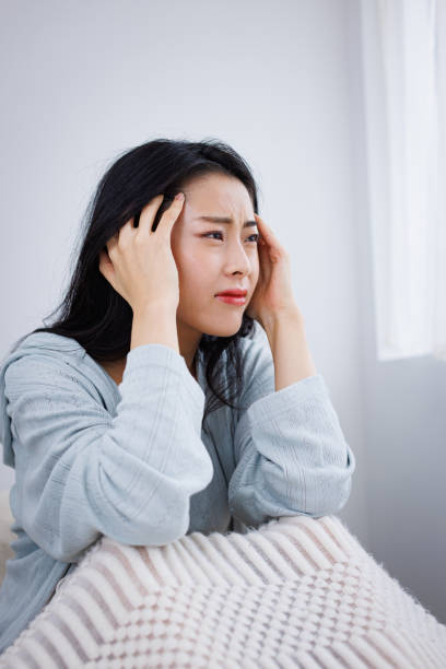 istock Young Asian woman in her bed suffering from headache 1837089536