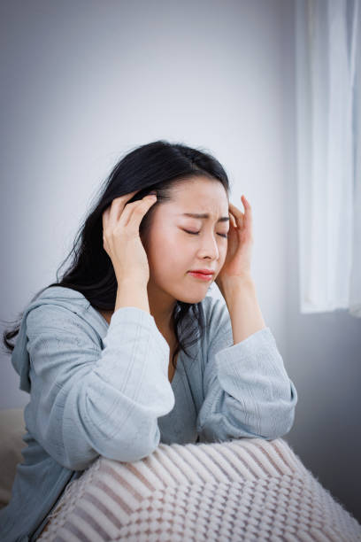 istock Young Asian woman in her bed suffering from headache 1837089537