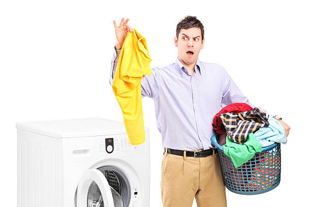 istock Young man next to washing machine holding dirty laundry 183709159