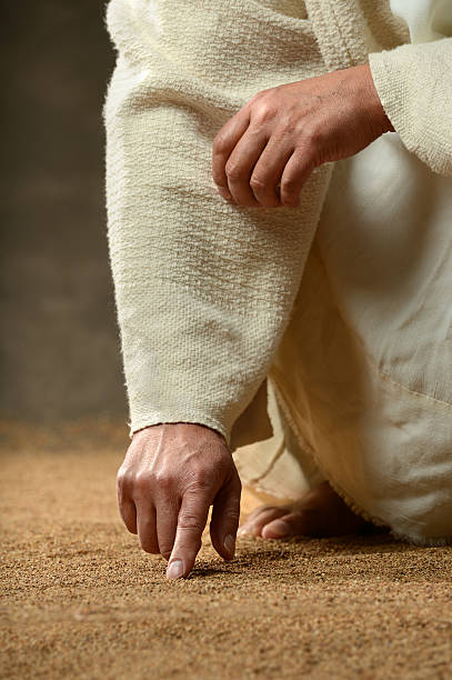 Jesus Finger Writing in the Sand stock photo