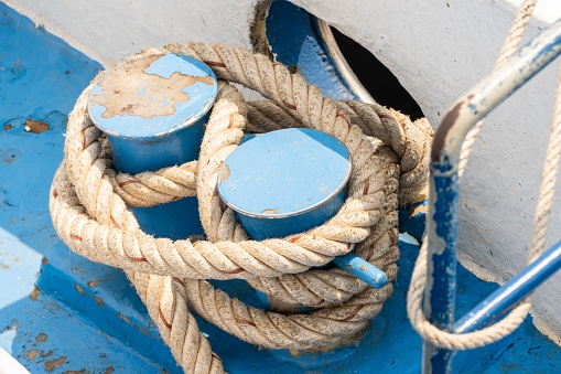 Close up of nautical rope with sailing knot on the bitts for boating and mooring vessel.