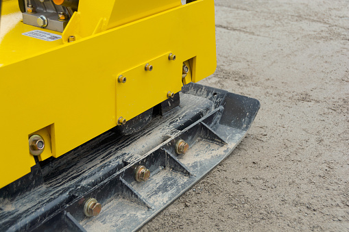 Vibratory plate compacts gravel base layer