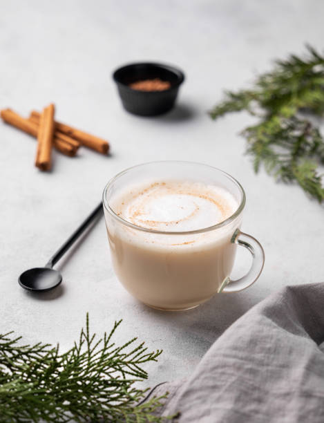 istock Spiced coffee latte or cappuccino with cinnamon sticks on a light background with fir branches. 1837155328