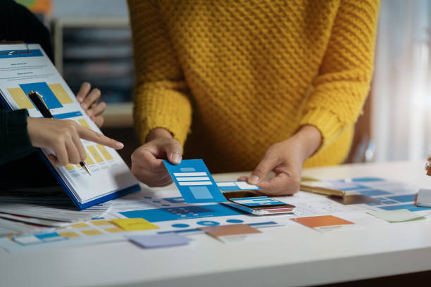 istock designer brainstorming about mobile app interface wireframe design with customer breif and color code at office. 1837155852