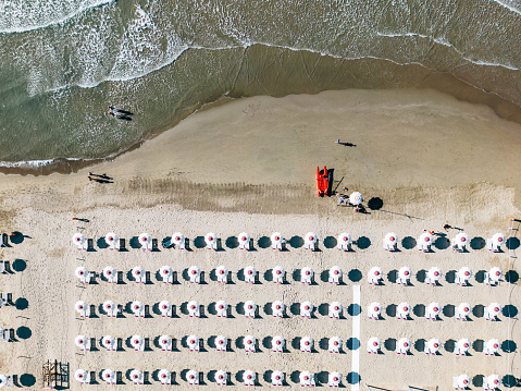 Aerial view of a beach with many beach umbrellas. Italian beach in summer.