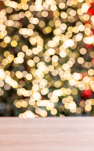 istock Wooden empty tabletop in front of a Christmas tree with red decorations and lights in blurred. 1837164027