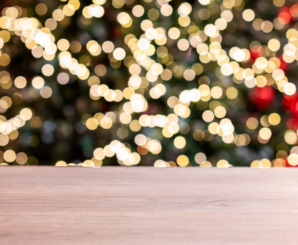 istock Wooden empty tabletop in front of a Christmas tree with red decorations and lights in blurred. 1837164296
