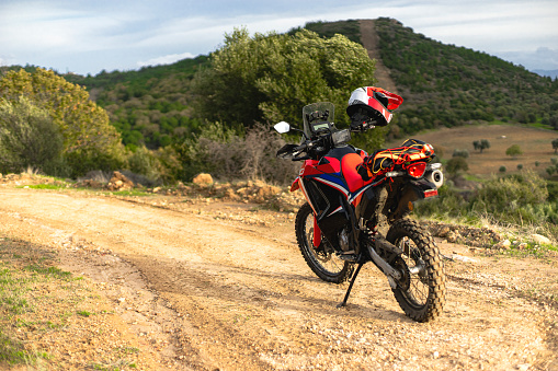 View of a dirtbike on the dirt road up to hill.