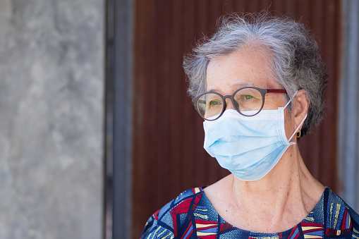 Portrait of an elderly woman wearing a face mask with a worried. Mask for protect virus, coronavirus, pollen grains. Concept of old people and healthcare.