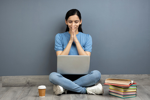 Photo of pretty girl using laptop on wooden floor