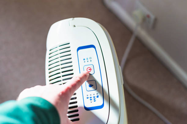 istock Man switching on dehumidifier while drying laundry at home 1837267087