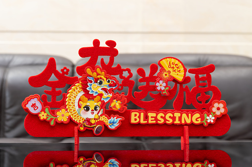 Chinese New Year of Dragon mascot paper cut in a living room background at horizontal translation of the Chinese words are the Dragon brings fortune and lucky no logo no trademark
