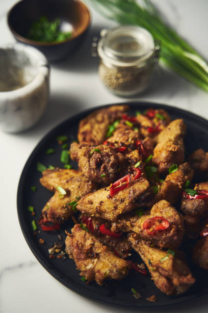 istock Chinese Salt and Pepper chicken wings. Crispy battered Deep fried chicken wings with vegetables seasoned with salt and pepper and then quickly sauteed with onions, garlic and chilies. 1837300577