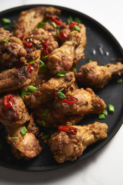 istock Chinese Salt and Pepper chicken wings. Crispy battered Deep fried chicken wings with vegetables seasoned with salt and pepper and then quickly sauteed with onions, garlic and chilies. 1837300578