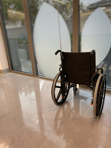 Close-up Empty wheelchair in front of a window of a Hospital outpatient clinic
