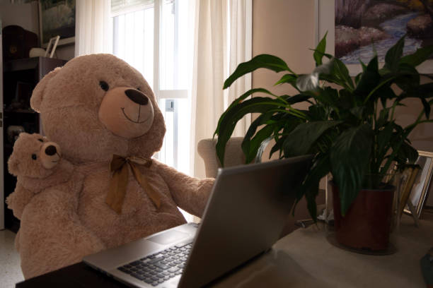 istock Teddy bear with baby bear telecommuting at home on a laptop 1837320740