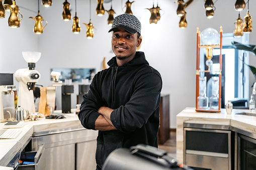 Portrait of a handsome young black barista working in a coffee shop in Kuwait City in Kuwait.