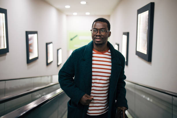 istock Young man standing on an escalator in a shopping mall 1837344153