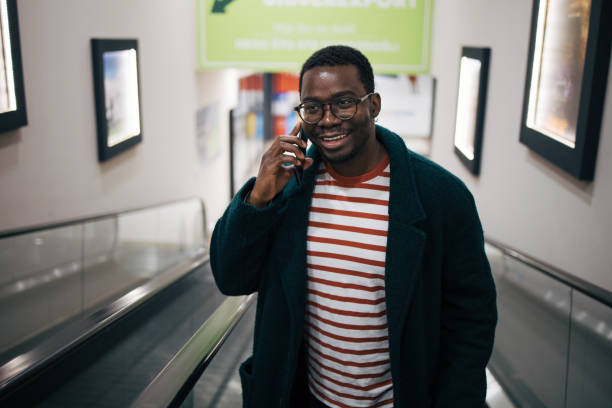istock Young man standing on an escalator in a shopping mall 1837344165