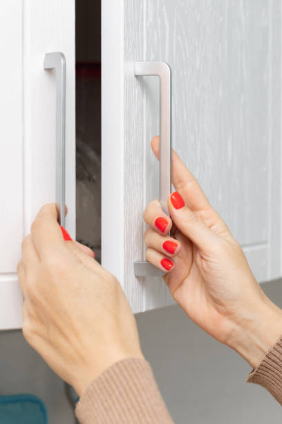 istock woman opens double doors of kitchen cabinet. 1837350441