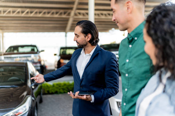 istock Car salesman talking with customer at dealership 1837370218