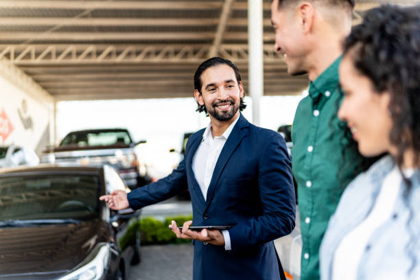istock Car salesman talking with customer at dealership 1837370219