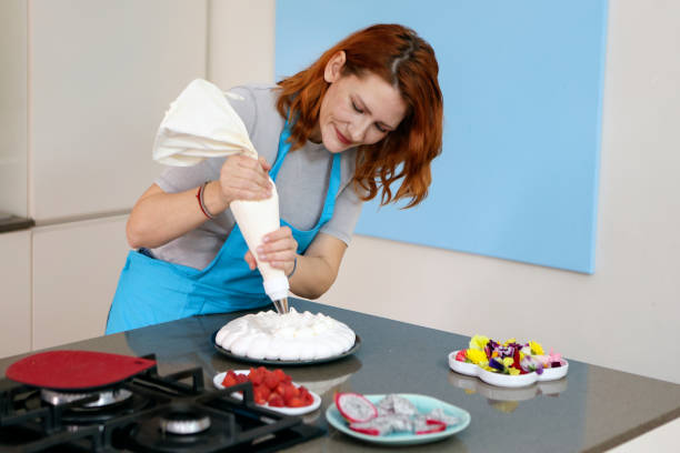 ajouter de la crème fouettée - baking cake making women photos et images de collection