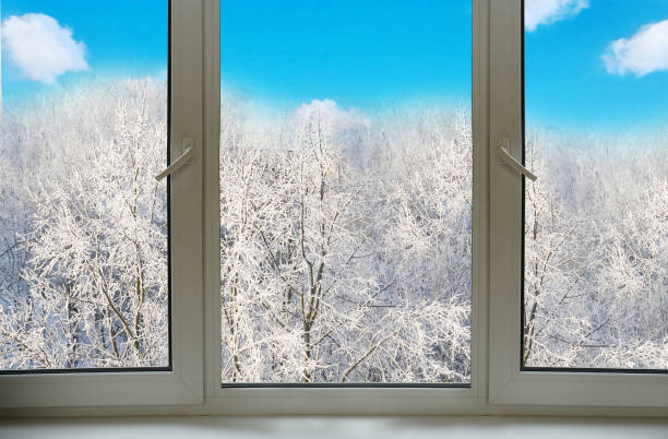 istock View from the window on a winter landscape with blue sky,  trees and falling snow. 1837408428