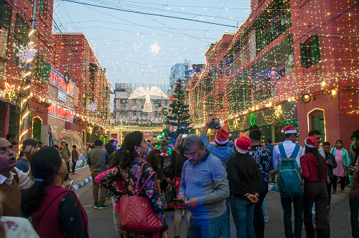 Kolkata, West Bengal. People are celebrating Christmas with colorful decorations and lighting in a city street.