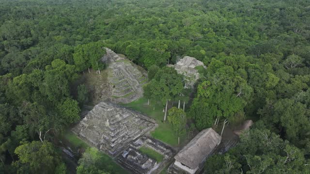 Old maya ruins in middle of lush green jungle at Yaxha near Tikal, aerial