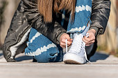 Teenage Girl on the Street Tying White Sneakers