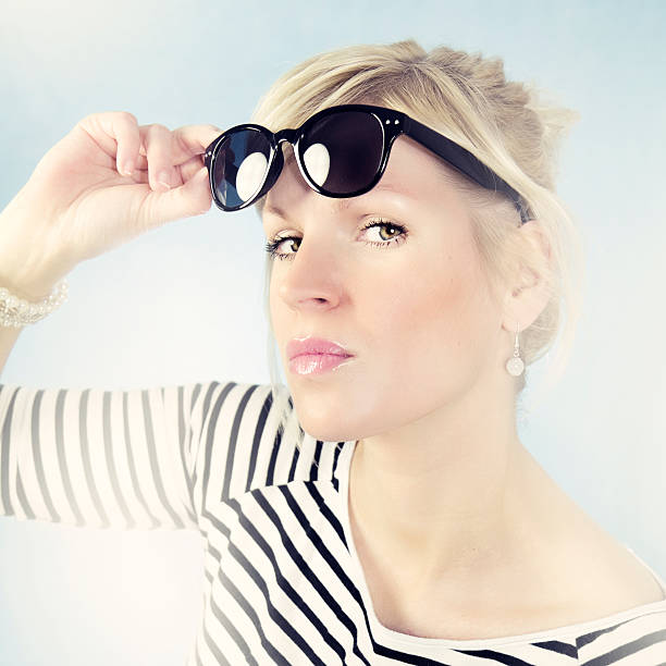 Attractive woman wearing Wayfarer- sunglases High key portrait  of a blonde attractive woman with light in background and Wayfarer- sunglases / cross processing hochsteckfrisur stock pictures, royalty-free photos & images