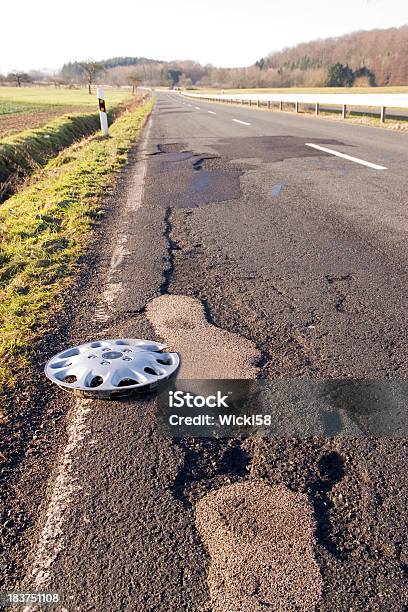 Hubcap On A Damaged Road Stock Photo - Download Image Now - Bumpy, Street, Asphalt