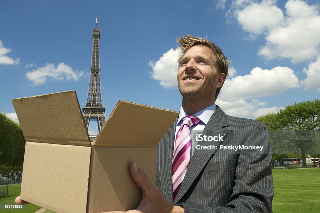 Sorridente Empresário detém Torre Eiffel em marrom caixa - Foto de stock de Fotografia - Imagem royalty-free