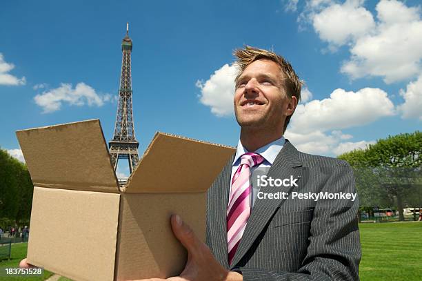 Foto de Sorridente Empresário Detém Torre Eiffel Em Marrom Caixa e mais fotos de stock de Fotografia - Imagem