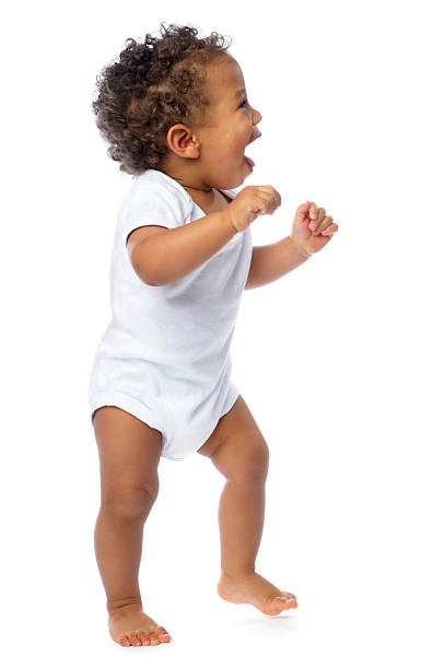 вид сбоку в счастливый ребенок гуляет изолирован на белом - baby1 стоковые фото и изображения