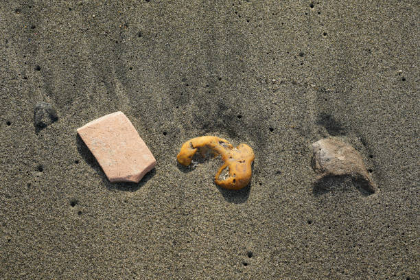 istock Three pebbles on the dark sea sand 1837519577